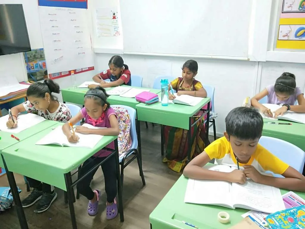 Young students happily engaged in activity-based interactive Tamilcube GOLD™ program.